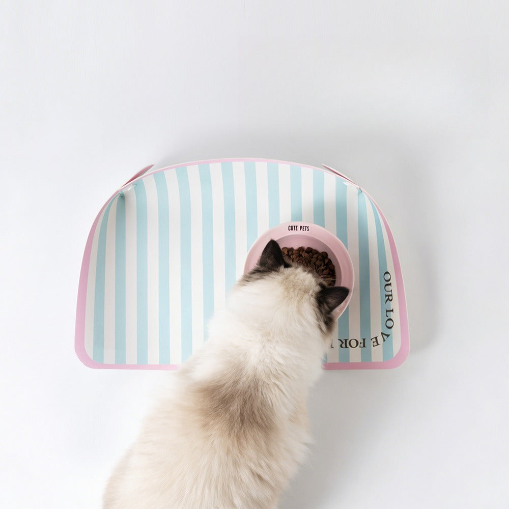 Fluffy cat eating on a mint stripe pet placemat