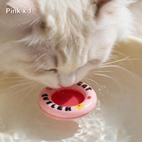 Pink float ring bobbing in a water bowl