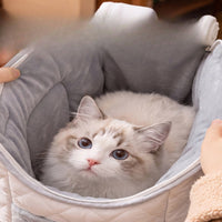 Cat resting inside the soft quilted interior of the carrier