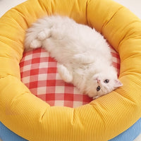 White cat relaxing in plush donut pet bed