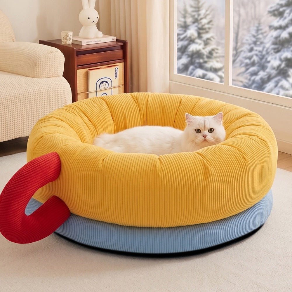 Cat sleeping in round bolster pet bed by the window