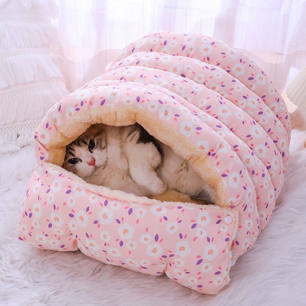 Cat lounging in pink floral burrow bed