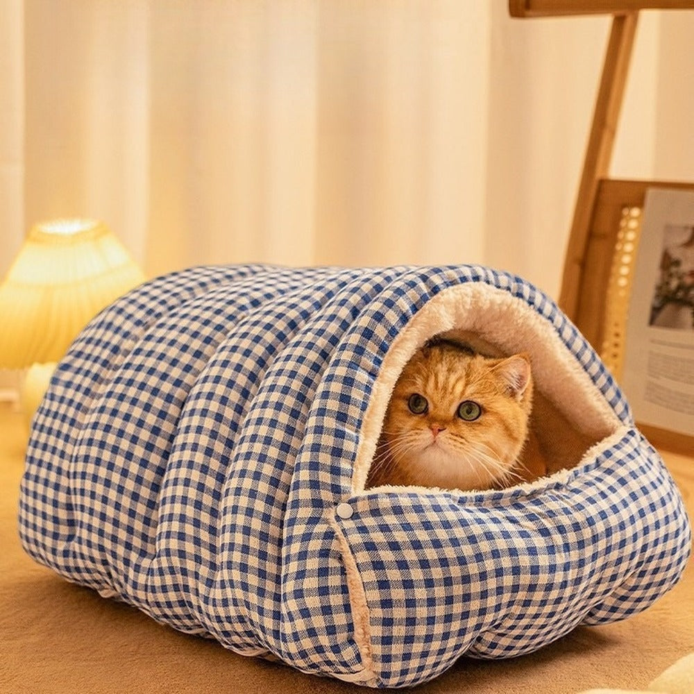 Ginger cat peeking out of blue plaid cat cave